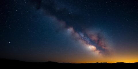 Fototapeta premium Starry night sky filled with twinkling stars over a dark silhouette of an expansive landscape, cosmos, galaxy, magical