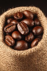 Freshly harvested dark roasted coffee beans are displayed in a rustic burlap sack, showcasing rich flavors typical of Brazilian coffee production