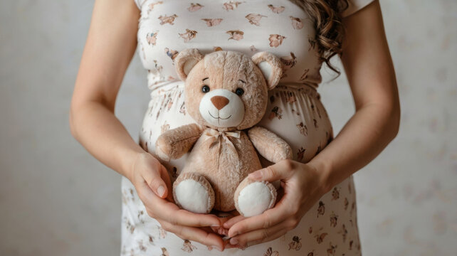 Preciosa mujer embarazada sosteniendo un osito de peluche
