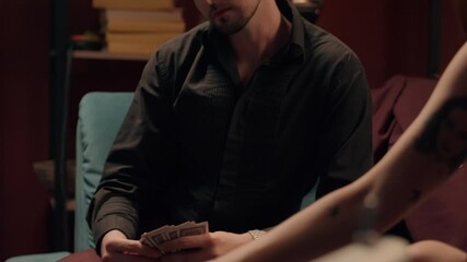 Two Caucasian poker players playing cards game blackjack woman female girl girlfriend play competition man male guy boyfriend date tournament gambling casino betting drink smoking cigar party at home