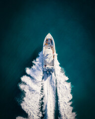 Top down shot of a boat at high speed taken with a drone in deep blue waters of the Caribbean © Sebastian