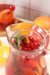 Delicious punch with rosemary in jug, closeup