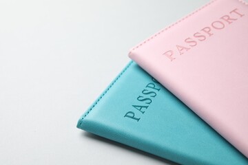 Passports in color covers on light background, closeup. Space for text