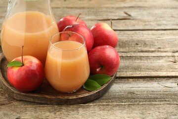 Tasty apple juice and fresh fruits on wooden table, closeup