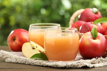 Tasty apple juice and fresh fruits on wooden table against blurred background, closeup