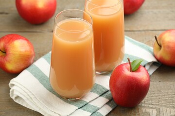 Tasty apple juice and fresh fruits on wooden table, closeup