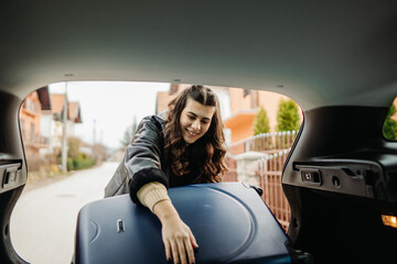Young caucasian woman packing suitcase preparing for travel