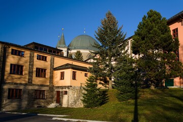 View of the towers and dome of the basilica through the pilgrimage houses. Hostyn. Czech Republic.