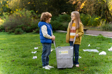 Small children picking up trash together sorting plastic waste into bags in park