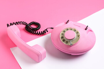 Pink retro telephone on color background