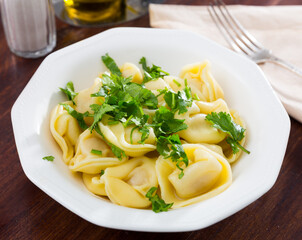 Plate of delicious freshly boiled ravioli with greens..