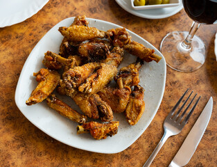 Portion of delicious fried chicken wings with a golden crust. Close-up image