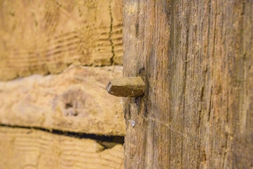 Clay wall with wooden nail sticking out of it. Ancient german farmers house
