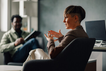 Businesswoman gesturing while talking to a colleague in office