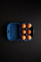 Brown Chicken egg on black background. Packaging. Free space.
