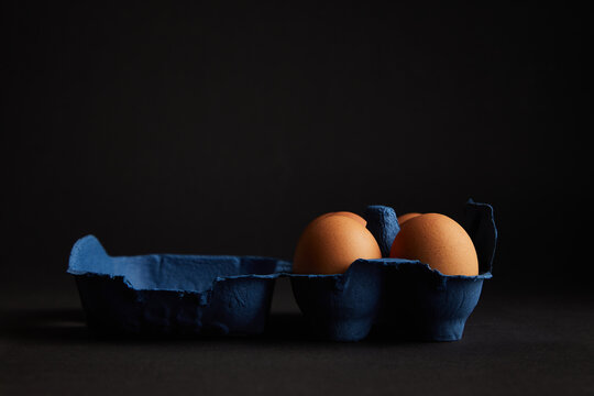 Brown Chicken egg on black background. Packaging. Free space.