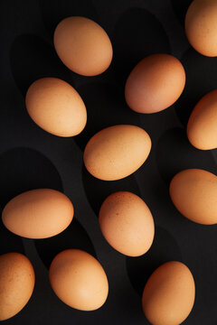 Chicken eggs on black background. View from the top