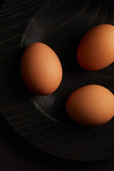 Chicken eggs on black background. View from the top