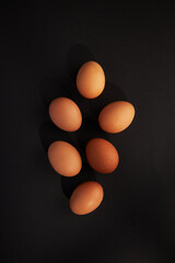 Chicken eggs on black background. View from the top