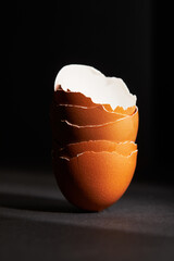 The pile of raw brown eggshells on black background. Free space.