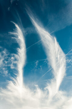 Ethereal cloud patterns are beautifully displayed against a captivating blue sky backdrop