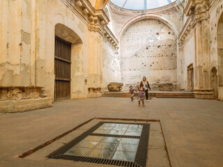 Latino family plays inside an old Catholic church which currently functions as a tourist attraction.