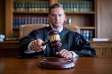 A detailed close-up of a judge’s wooden gavel on a courtroom table, symbolizing law, order, and justice.