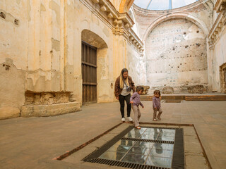Latino family plays inside an old Catholic church which currently functions as a tourist attraction.