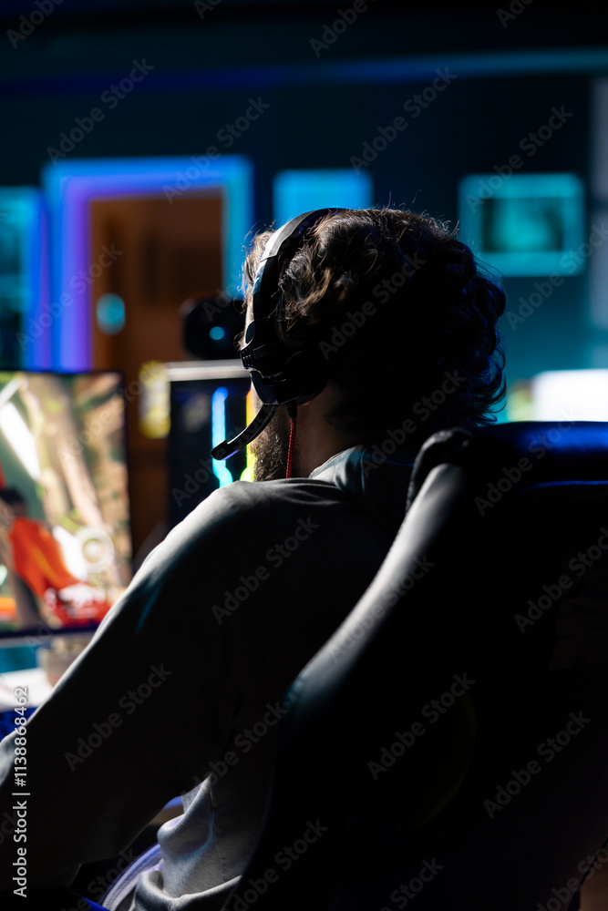 Poster man relaxing by playing entertaining videogame on pc at computer desk late at night. close up shot o