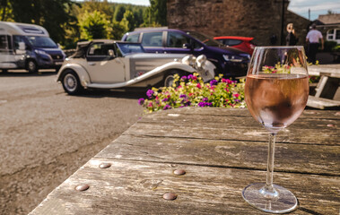 glass of wine over background with retro cars, traveling in the UK, holiday concept