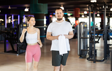 Guy and girl leave gym, after completing classes they go to exit of room. Visitors of sports club...
