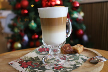 New Year's cappuccino on the background of a Christmas tree with toys.
