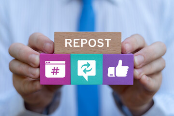 Businessman holding colorful blocks with icons sees text: REPOST. Repost sharing viral content...