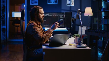 Developer writing lines of code on multimonitor PC setup during remote job shift. IT expert doing...