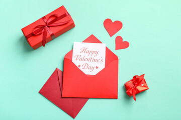Envelopes with gift card, boxes and paper hearts on turquoise background. Valentine's day celebration
