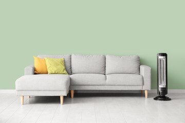 Interior of stylish living room with modern electric heater and grey sofa
