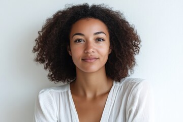Natural Portrait of a Young Woman with Curly Hair Against a Minimalist Background