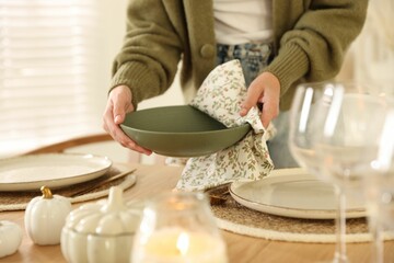 Woman setting table for dinner at home, closeup