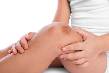 Fototapeta premium Child with bruise on leg against white background, closeup