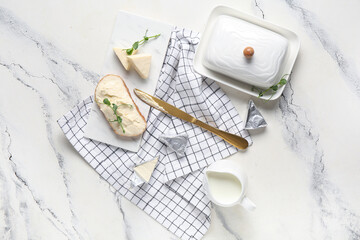 Composition with bread, triangles of tasty processed cheese, knife and milk on light background