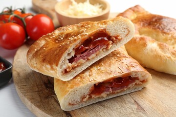 Pieces of fresh calzone pizza on wooden table, closeup