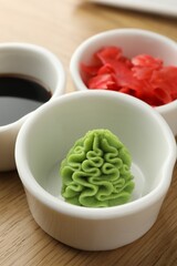 Hot wasabi paste, soy sauce and ginger on wooden table, closeup