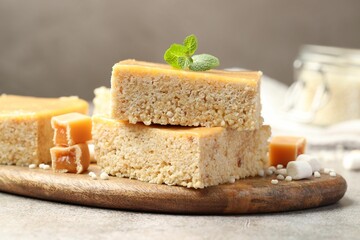 Delicious puffed rice bars, candies and mint on gray textured table, closeup