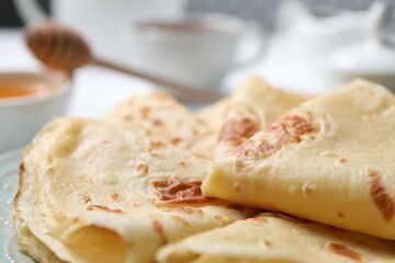 Delicious folded crepes on table, closeup view
