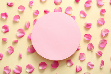 Blank card with beautiful rose petals on beige background