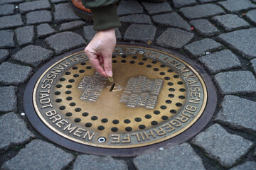 Bremen, Germany, December 4, 2024: Bremen Hole, underground donation box in the pavement of the market square. When a coin is inserted, the animal sounds of the Bremen Town Musicians can be heard