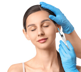 Young girl receiving filler injection in face against white background