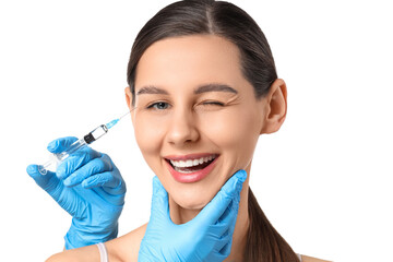 Young girl receiving filler injection in face against white background