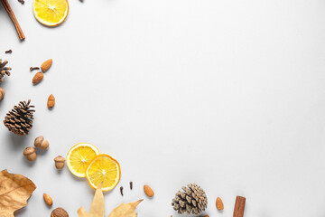 Composition with dried orange slices, spices, acorns and pine cones on grey background