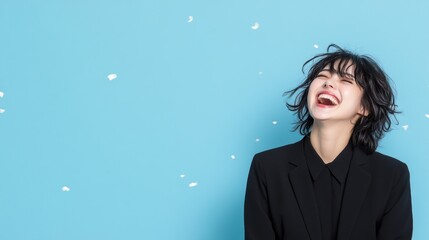 Fototapeta premium Joyful woman laughing against a blue background with confetti.